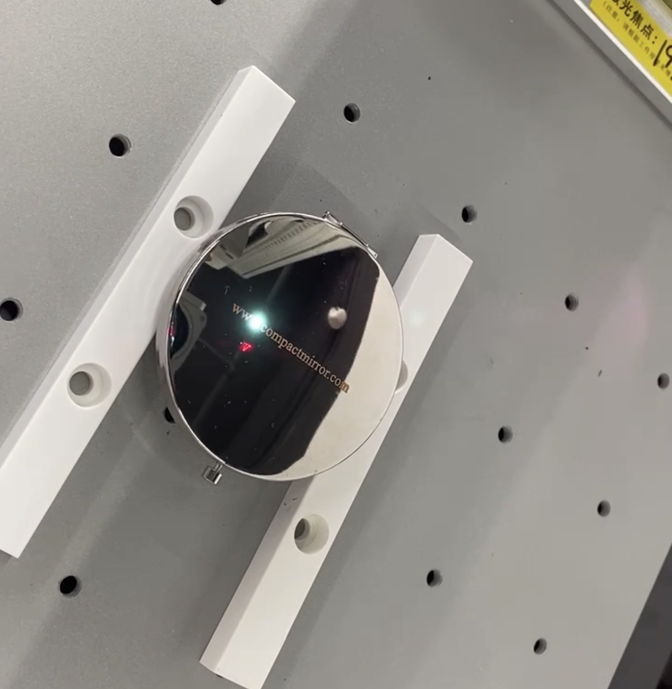Laser engraving a custom design onto a round metal compact mirror