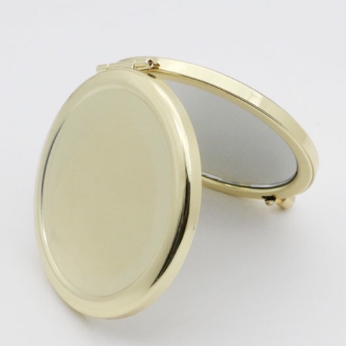Plain gold-tone round metal compact mirror shown partially open