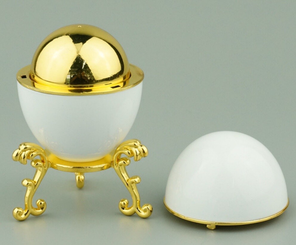 Open white enamel Hen Egg shell revealing a high-gloss gold-plated yolk