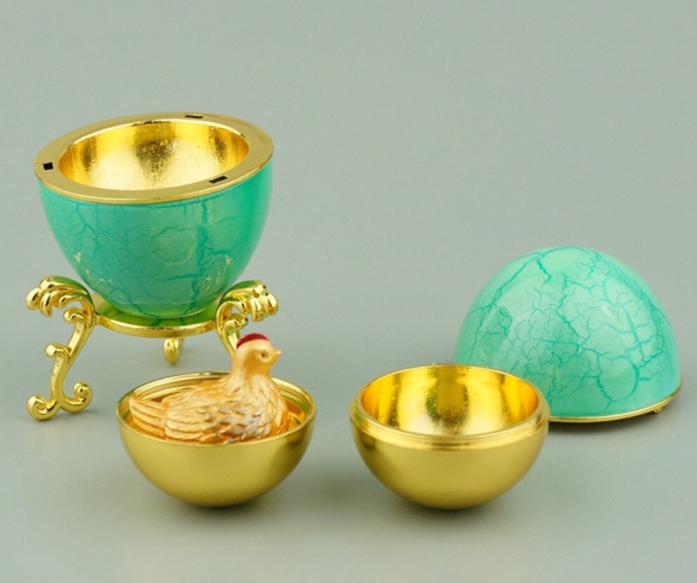 Turquoise crackle Hen Egg reproduction opened to reveal a golden yolk and miniature hen