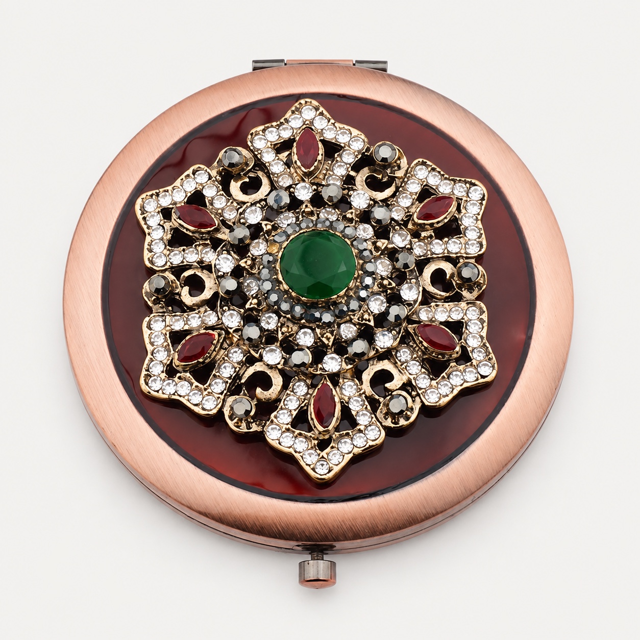 Vintage-inspired compact mirror with an ornate jeweled metal medallion