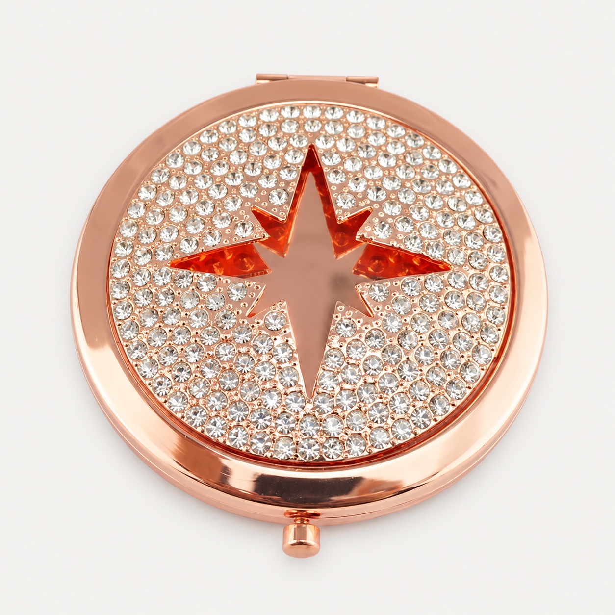 Rose-gold compact mirror covered with clear crystals around a star motif