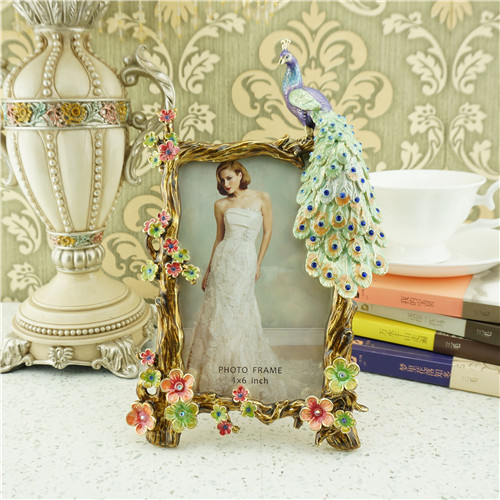A dimensional jeweled peacock and blossom metal photo frame