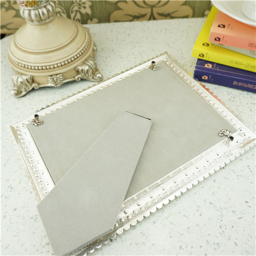 Rear view of a metal photo frame showing its easel, backing and swivel tabs